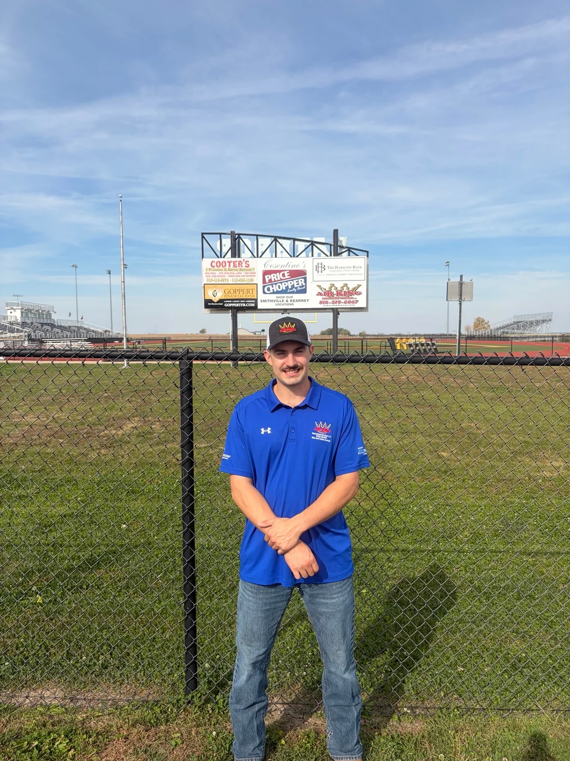 Air King team member in front of the stadium sponsor board
